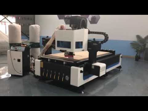 ATC CNC router machine changing tools and cutting a panel